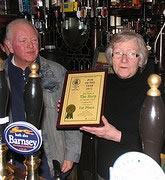 Landlady, Bridget Walsh receives the award from Branch chairman, Less Maggs